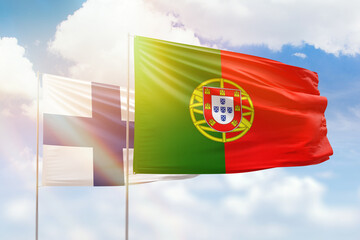 Sunny blue sky and flags of portugal and finland