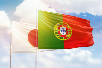 Sunny blue sky and flags of portugal and japan