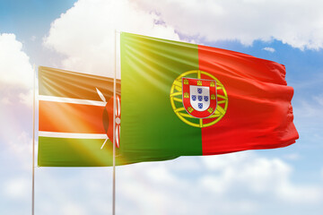Sunny blue sky and flags of portugal and kenya