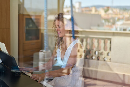 Woman Playing The Piano Outside The Window