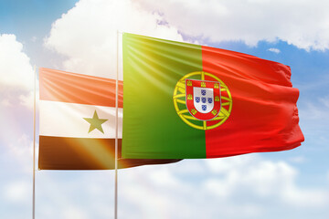 Sunny blue sky and flags of portugal and syria