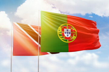 Sunny blue sky and flags of portugal and trinidad and tobago