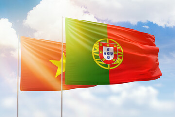 Sunny blue sky and flags of portugal and vietnam