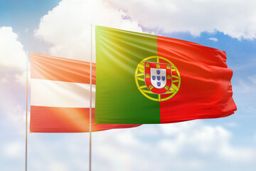 Sunny blue sky and flags of portugal and austria