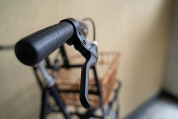 Handlebar grip with brake lever from a vintage city bike parked in the stairwell