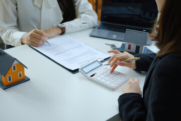 Guarantee, mortgage, contract, contract, signed, real estate agent or bank officer pointing a calculator, submits a bid with a customer to buy a home before signing to make a deal