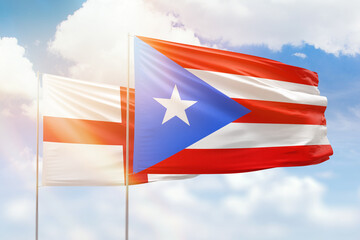 Sunny blue sky and flags of puerto rico and england