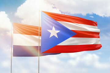 Sunny blue sky and flags of puerto rico and netherlands