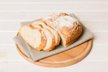 Assortment of freshly sliced baked bread with napkin on rustic table top view. Healthy unleavened bread. French bread slice