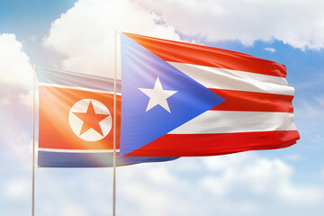 Sunny blue sky and flags of puerto rico and north korea