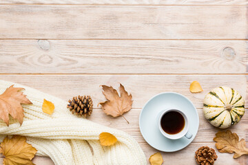 Flat lay composition with colorful Autumn cup of coffee and leaves on a color background. top view