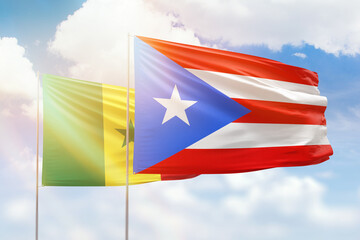 Sunny blue sky and flags of puerto rico and senegal