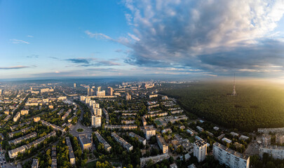 Aerial panorama view on sunrise morning city with telecommunication tower in forest near...