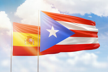 Sunny blue sky and flags of puerto rico and spain
