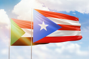 Sunny blue sky and flags of puerto rico and sudan