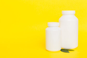 supplement pills with medicine bottle health care and medical top view. Vitamin tablets. Top view mockup bottle for pills and vitamins with green leaves, natural organic bio supplement, copy space