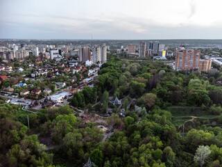 Fototapeta na wymiar Aerial view on green summer Kharkiv city center popular recreation park Sarzhyn Yar and modern residential district. Botanical garden with water spring and sports playground area