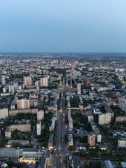 Naklejka na ściany i meble Aerial view Kharkiv city center Nauky avenue. Pavlove Pole and Central area with multistory high buildings in evening with street lights illumination. Vertical