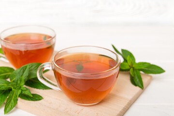 Cup of mint tea on table background. Green tea with fresh mint top view with copy space