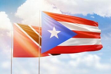 Sunny blue sky and flags of puerto rico and trinidad and tobago