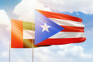 Sunny blue sky and flags of puerto rico and uae