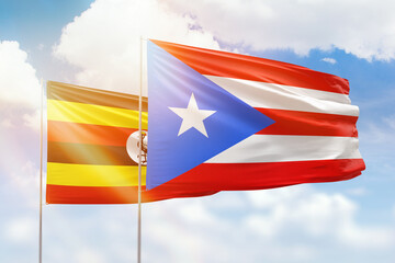 Sunny blue sky and flags of puerto rico and uganda