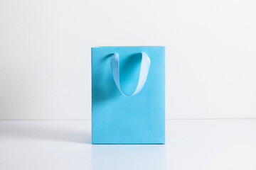 Blue bag on white background. Blue shopping paper bag with handles.