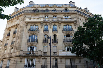 The facade of traditional French house with typical balconies and windows. Paris.