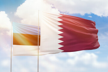 Sunny blue sky and flags of qatar and estonia