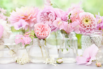 Delicate blooming light pink flowers in bottles, summer blossoming floral festive background, bouquets floral card, selective focus, shallow DOF