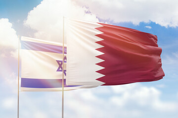 Sunny blue sky and flags of qatar and israel