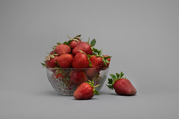 strawberries in a bowl. strawberries in a glass plate on a gray background