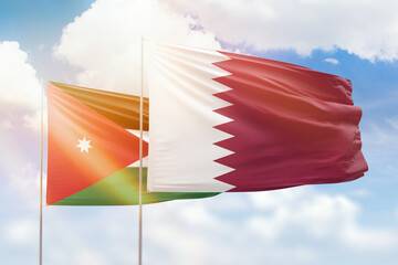 Sunny blue sky and flags of qatar and jordan