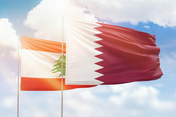 Sunny blue sky and flags of qatar and lebanon