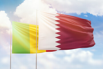 Sunny blue sky and flags of qatar and mali