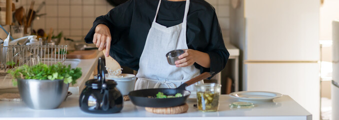 キッチンで料理をするエプロン姿の女性　