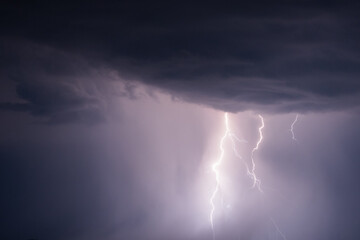 Dark stormy sky with lightning strikes and thunderstorm clouds at night. Dramatic, nature, danger,...