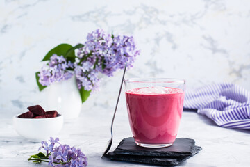 Sweet beetroot latte in a glass and beets in a bowl on the table. Healthy homemade vitamin drinks