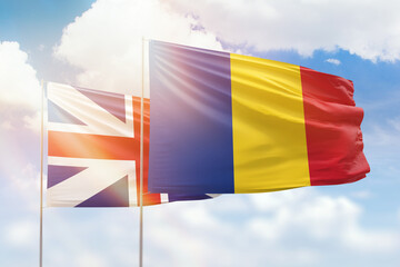 Sunny blue sky and flags of romania and great britain