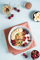 Granola with cherry, banana and flax seeds in a bowl. Homemade breakfast. Top and vertical view.