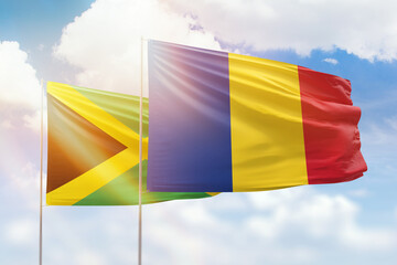 Sunny blue sky and flags of romania and jamaica
