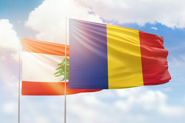 Sunny blue sky and flags of romania and lebanon