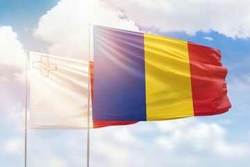 Sunny blue sky and flags of romania and malta