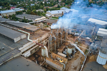 Aerial view of wood processing factory with smoke from production process polluting atmosphere at plant manufacturing yard