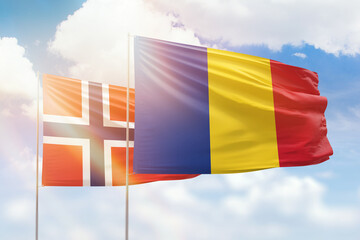 Sunny blue sky and flags of romania and norway