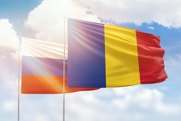 Sunny blue sky and flags of romania and russia