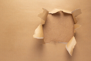 Cardboard torn paper as background texture. Brown paper hole