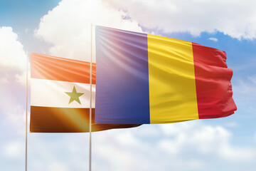 Sunny blue sky and flags of romania and syria