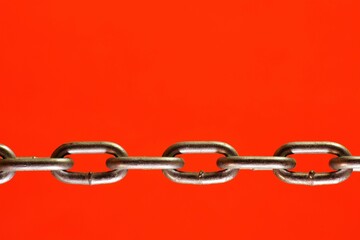 A chain of links is isolated on a red background with free space for text and creativity.