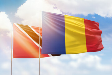 Sunny blue sky and flags of romania and trinidad and tobago